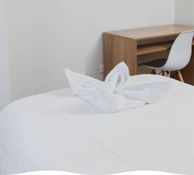 Toalla decorativa en forma de flor sobre la cama