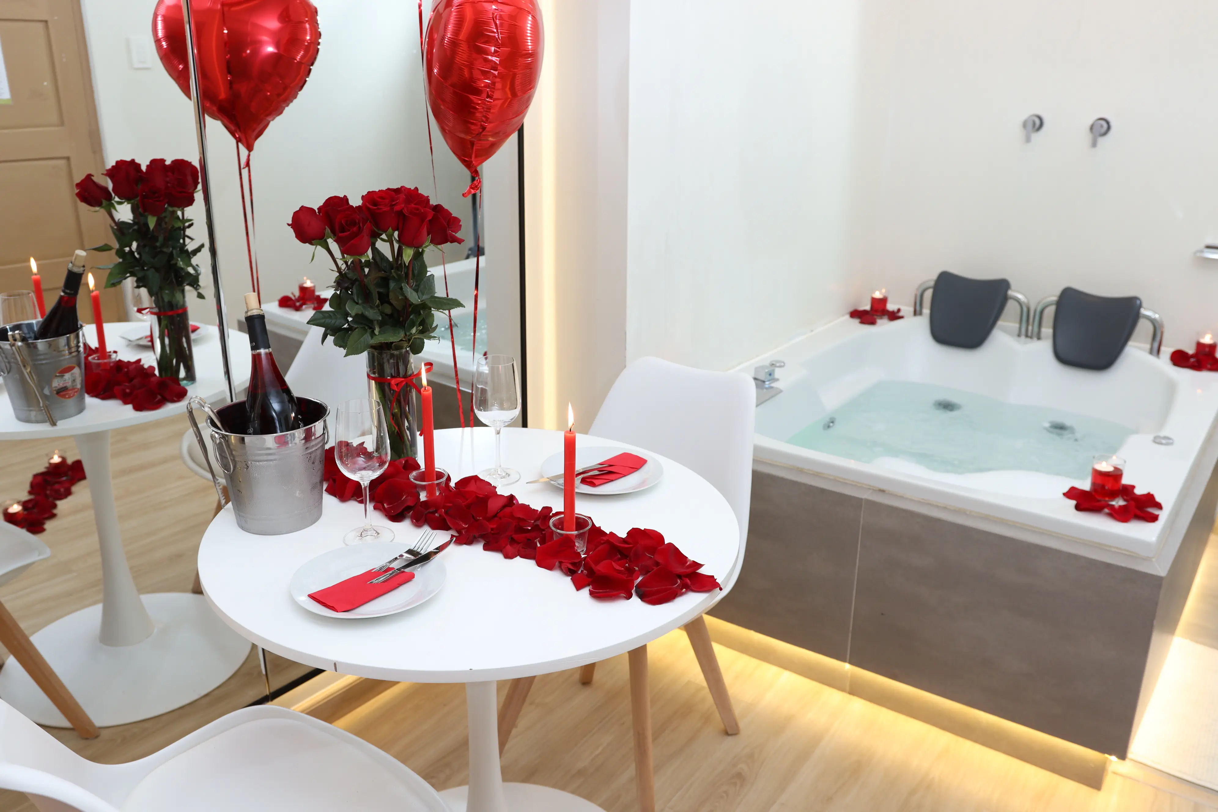 Cama decorada con corazón de pétalos de rosa y listones